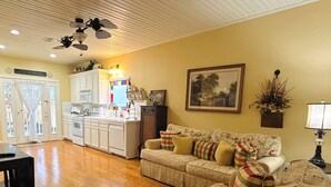 Amplia sala de estar con sofá, una mesa de comedor y una zona de cocina.