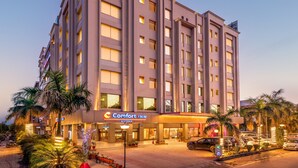 Un hotel Comfort Inn con una fachada moderna, varios pisos y una entrada bien iluminada.