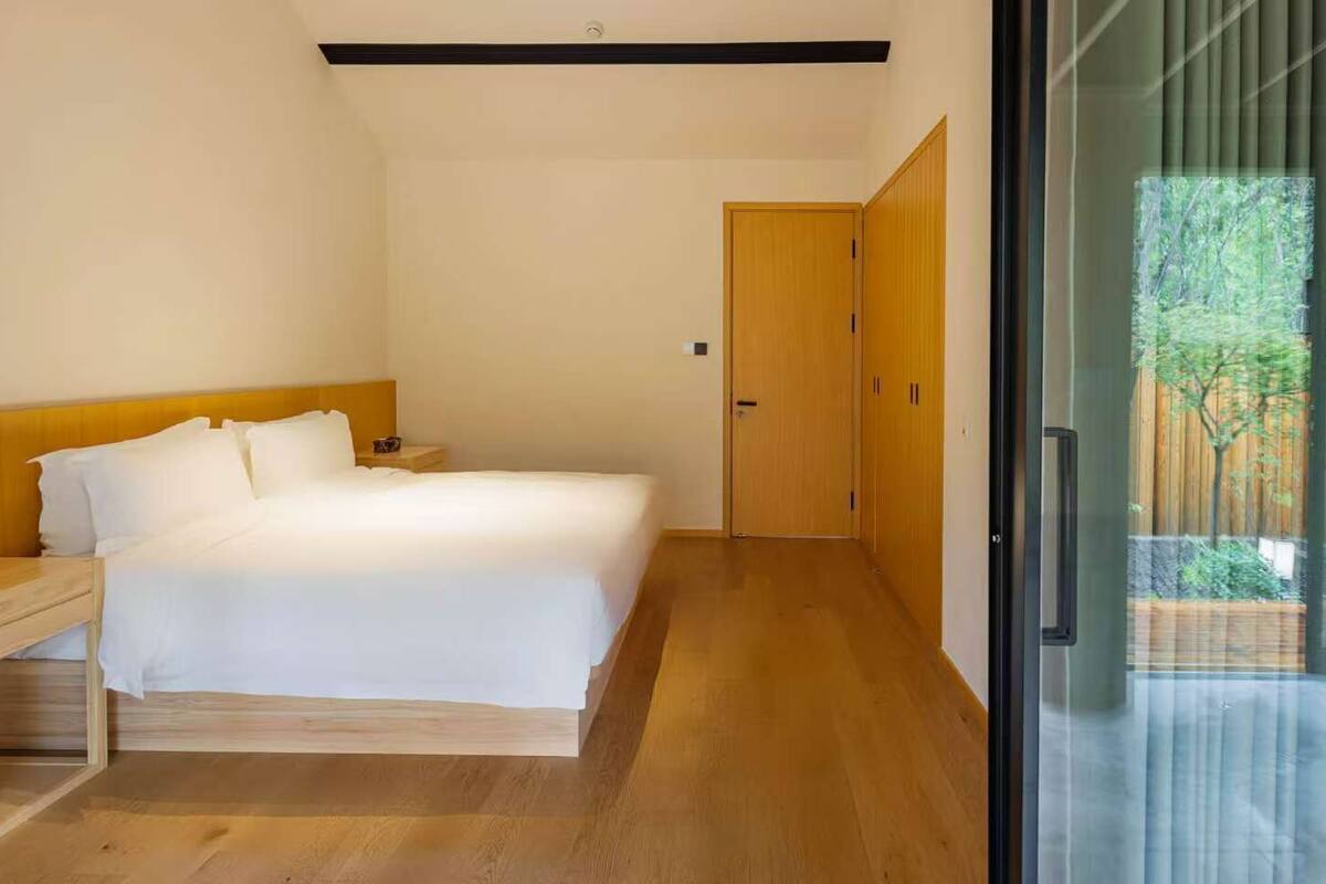 Quarto com cama, mesa de cabeceira e guarda-roupa.