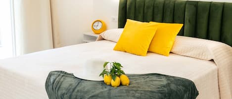 A neatly made bed with a green headboard, white bedding, and two yellow pillows.