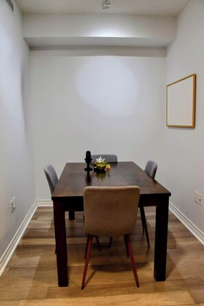 Enjoy meals in this cozy dining area with a table and chairs, a decorative item, and a framed picture on the wall.