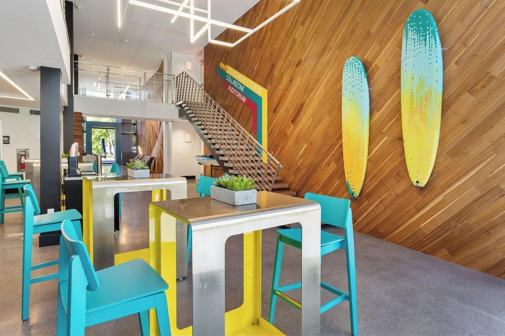 A modern interior with a wooden wall, a staircase, and a surfboard decoration.