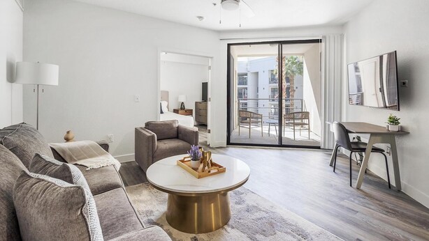 Un salon moderne comprenant un canapé, une table basse et un coin repas avec une chaise et une petite table.