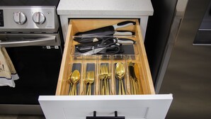 A drawer with kitchen utensils including scissors, a knife, and various spoons and forks. - Fayetteville Elite Escape – Close to Base & VA Hospitals (Fayetteville)