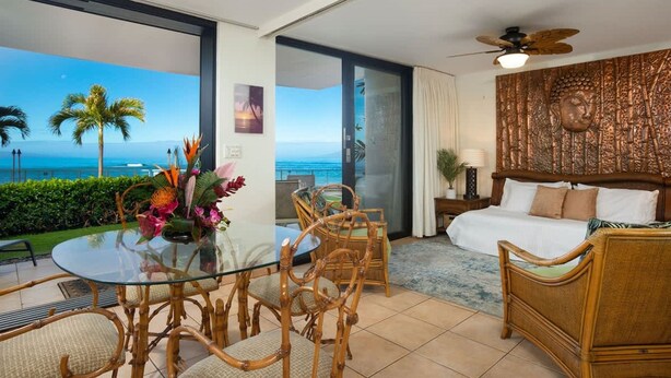 A hotel room with a glass table, wicker chairs, a bed, and a view of the ocean. - Zen by the Sea Ground-level Paradise With Ocean Views Whales Watching (Lahaina)