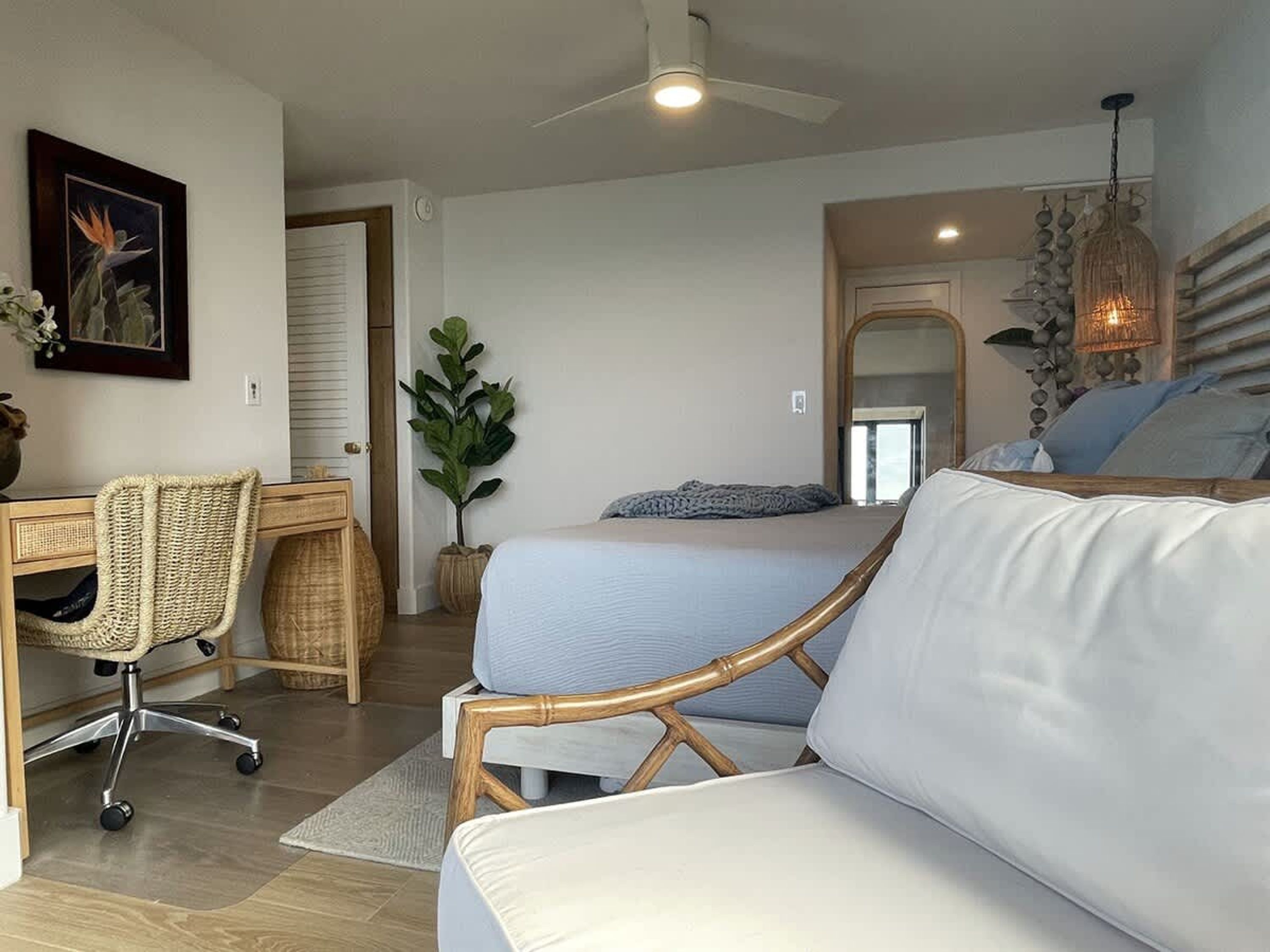Un dormitorio moderno con cama, dos sofás, un escritorio y una silla.