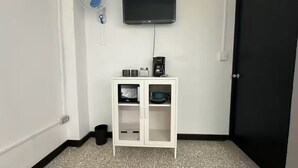 A small room with a white cabinet, a black door, a white wall, and a black floor. - Quaint Downtown Loft/WI-FI (San José)