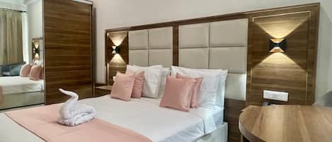 Una camera da letto ordinata con un grande letto, una testiera in legno e lampade ai comodini.