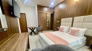 A modern bedroom with a bed, bedside tables, a desk, a chair, and a wardrobe. - Hôtel La Pivoine (Abidjan)