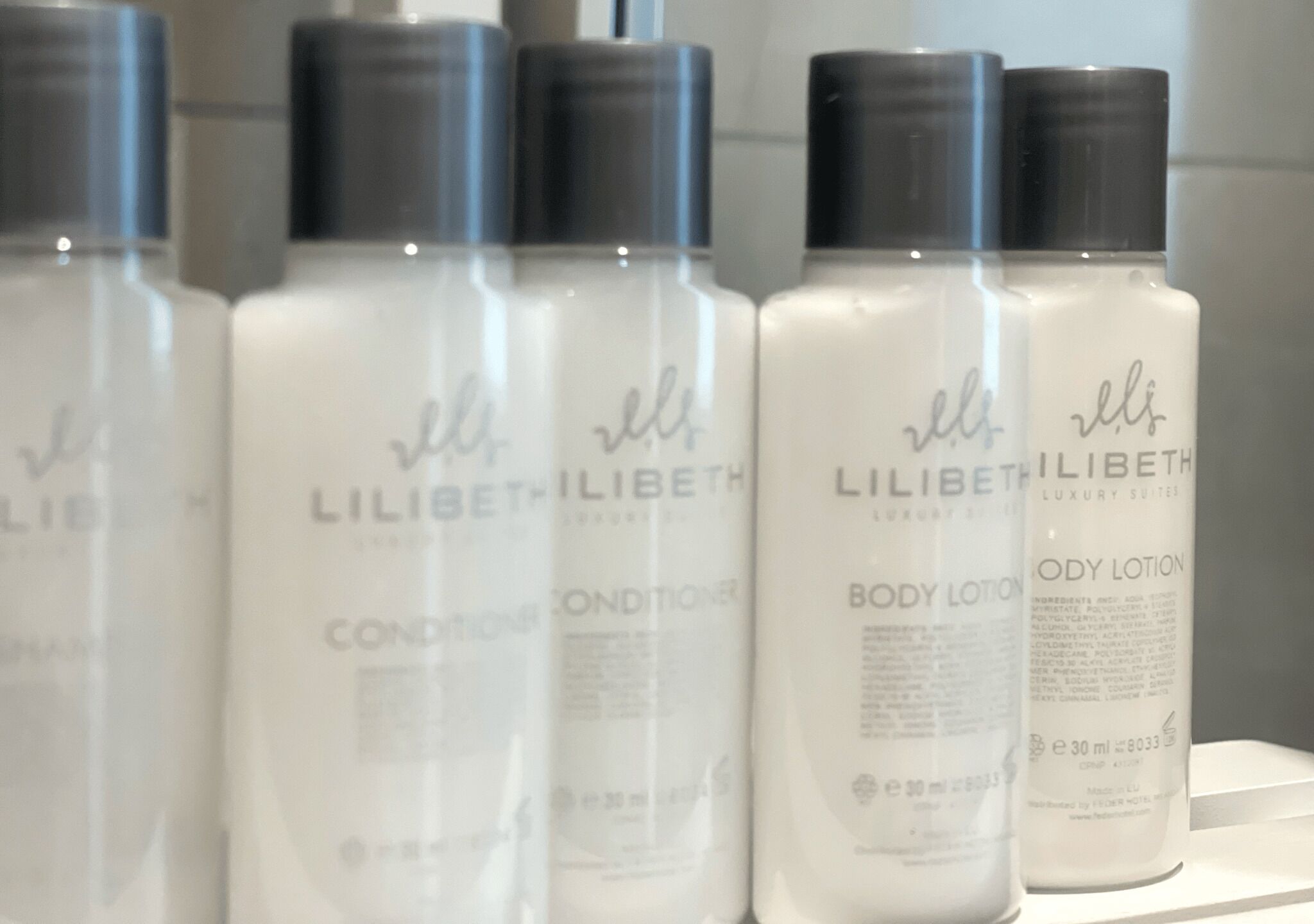 A row of LILIBETH LUXURY SUITES body lotion bottles.