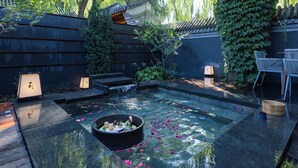 A traditional Japanese garden with a koi pond, wooden benches, and a bamboo fence. - Beijing XiaoTang YiPiao Hot Spring Resort (Changping)