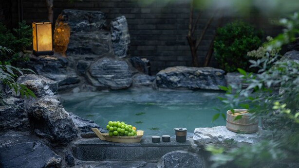 A serene garden with a pond, rocks, and a lantern. - Beijing XiaoTang YiPiao Hot Spring Resort (Changping)