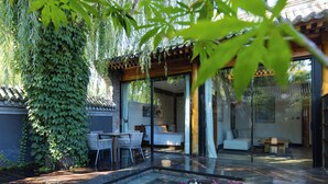 A modern outdoor area with a hot tub, seating, and a covered patio. - Beijing XiaoTang YiPiao Hot Spring Resort (Changping)