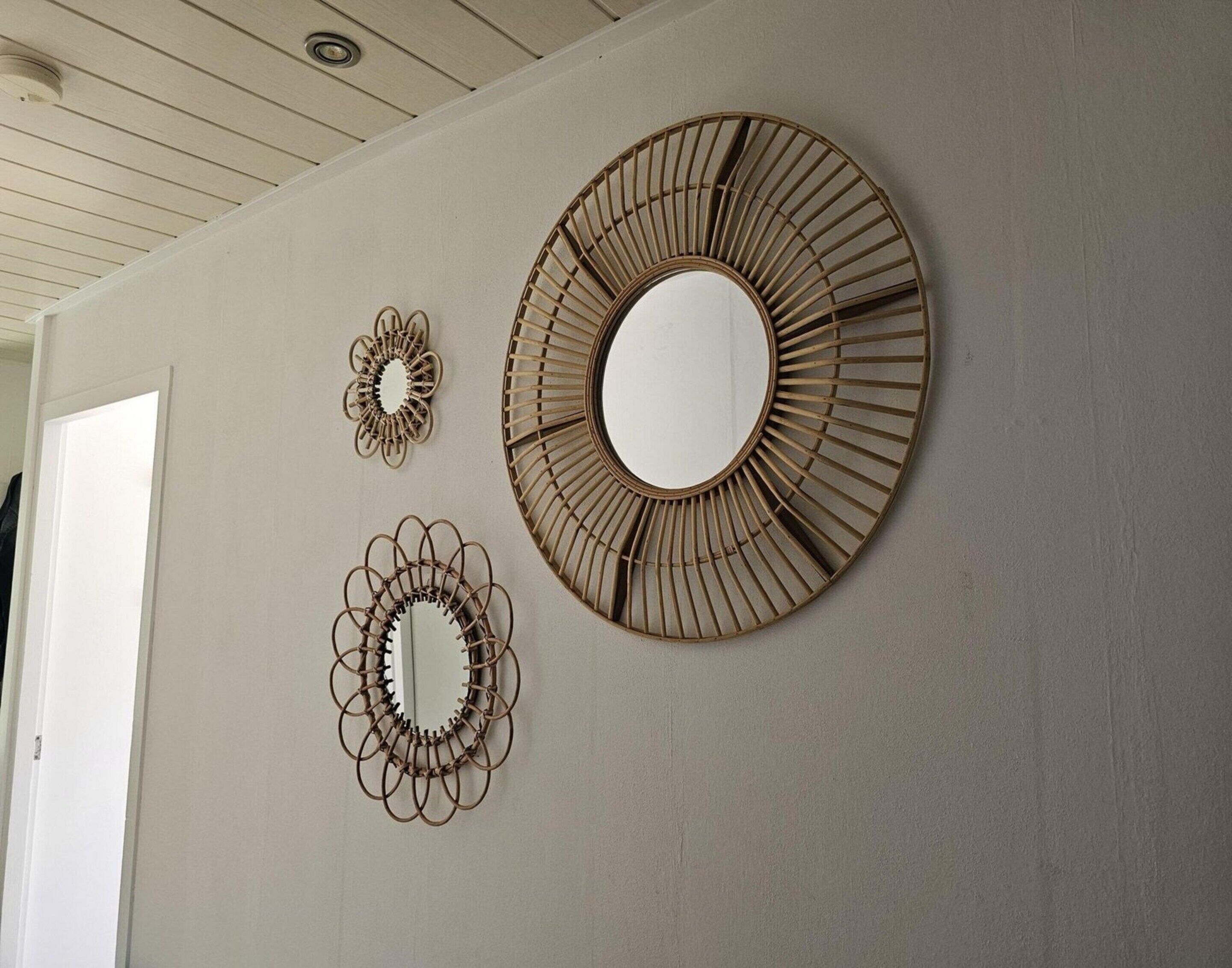 Three wall-mounted mirrors with different designs.