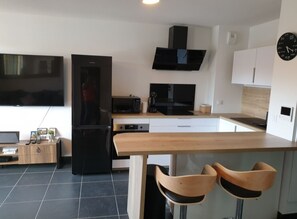 Enjoy cooking in this well-equipped kitchen with a central island, flat-screen TV, and microwave.