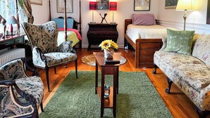 A well-furnished bedroom with a bed, two bedside tables, a chair, a sofa, and a small table with a vase of flowers. - Charming 1-bedroom apartment in fabulous Princeton with WiFi, AC (Princeton)