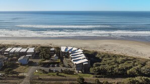 Vista aérea de una zona costera con una hilera de edificios, una playa y el océano.