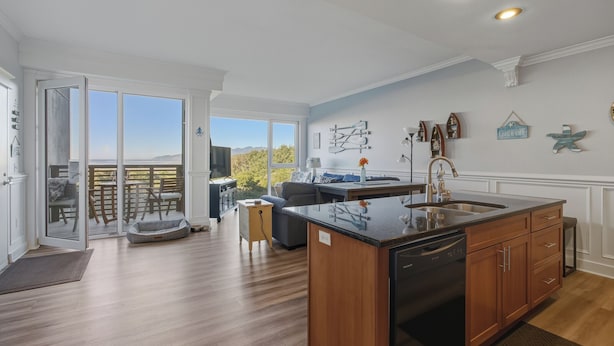 Una cocina moderna con una isla grande, armarios de madera y vistas al exterior.