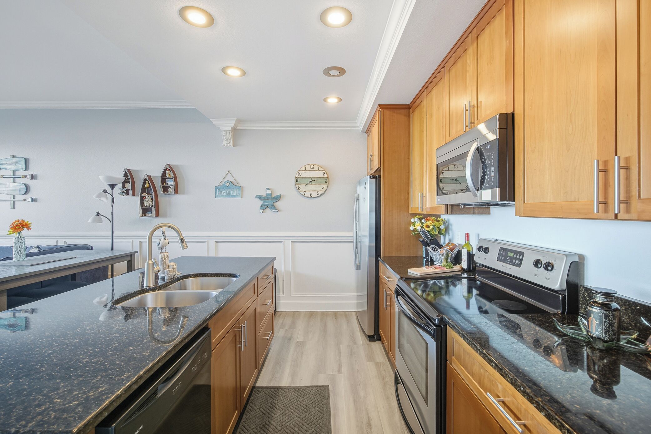 A modern kitchen with wooden cabinets, stainless steel appliances, and a granite countertop.