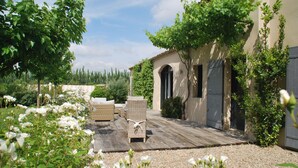 Een binnentuin met een pergola, buitenmeubilair en een gebouw met boogvensters.