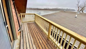 A wooden deck with a yellow railing overlooking a body of water. - Penthouse w/ Boho Loft, Jacuzzi, + Balcony -3 BR (Saint Joseph)