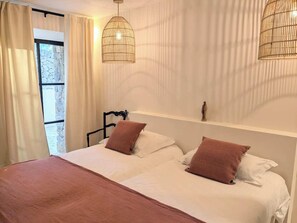 A double bed with two pillows, a bedside table, and a hanging light fixture. - Luxury villa - air-conditioned - pool - sleeps 14, 7 bedrooms and 7 bathrooms, 11 beds (Sanary-sur-Mer)