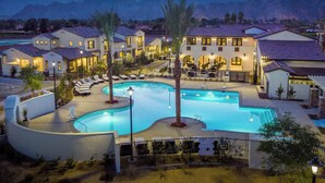 Un resort con piscina, varias villas y montañas al fondo.