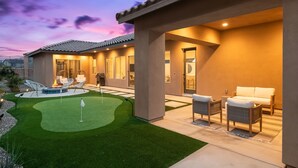 Propiedad residencial con patio, mobiliario exterior y pequeño jardín.
