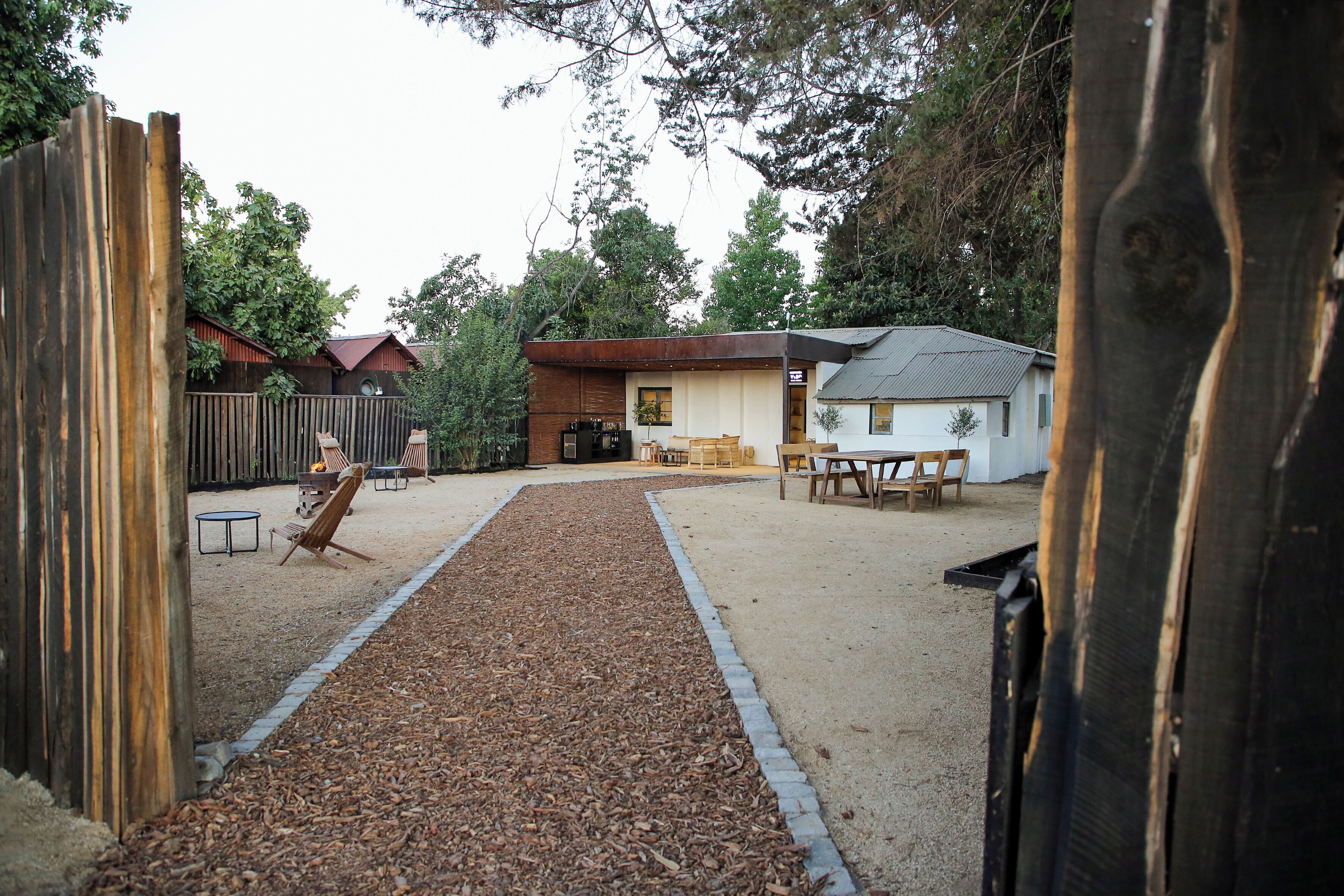 A backyard with a wooden deck, a barbecue grill, and outdoor furniture.