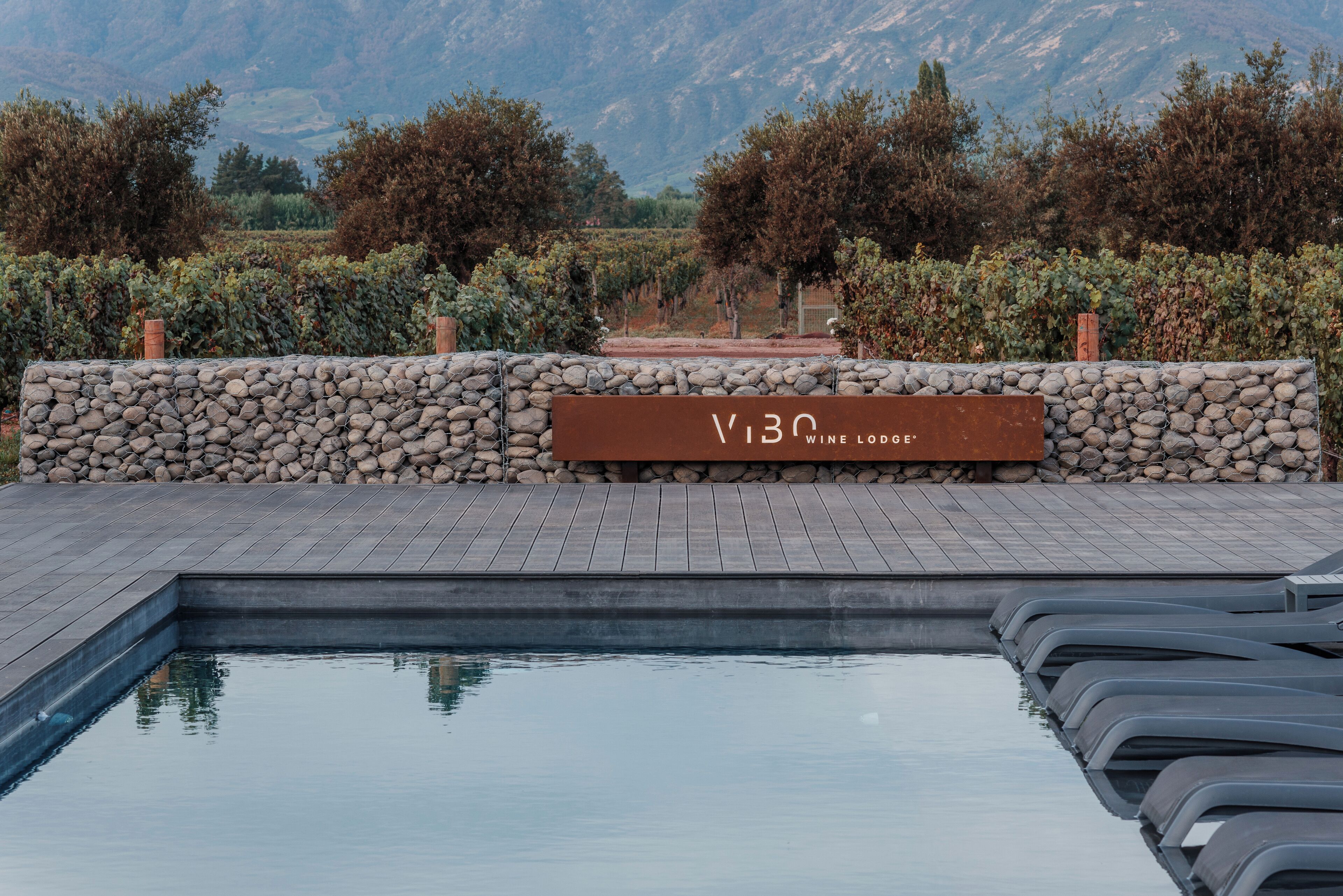 A stone wall with a sign reading "V130 Wine Lodge."