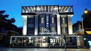 A modern hotel with a prominent sign, a rooftop lounge, and a glass facade. - Marrakesch Hotel Tuzla (Tuzla)