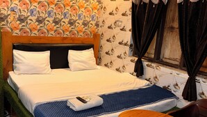 A hotel room with a bed, a small round table, and a patterned floor. - Plush hotels (Bhubaneshwar)