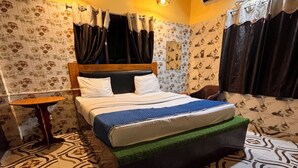 Ein Schlafzimmer mit einem Bett, einem kleinen Tisch, strukturiertem Wandpapier und einem Fliesenboden.