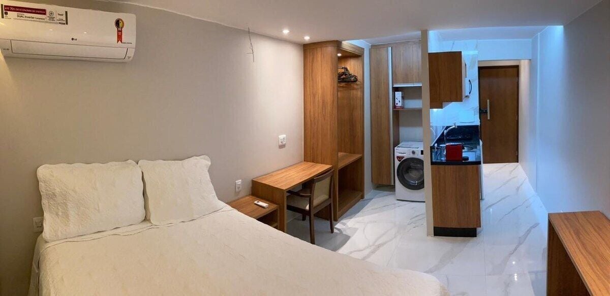 Una habitación pequeña con cama, escritorio y armario empotrado.