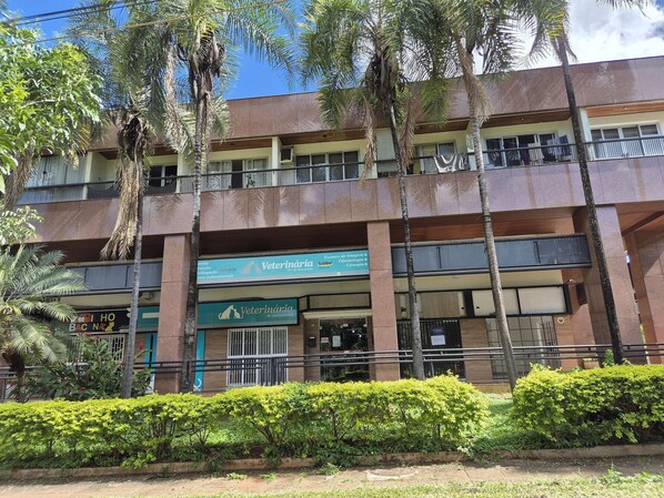 A multi-story building with a veterinary clinic on the ground floor, featuring a signboard with the clinic's name and services.