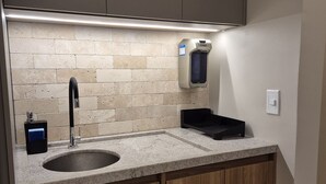 Een keuken met een granieten aanrecht, een spoelbak en houten kastjes.