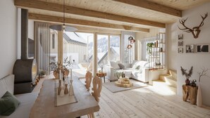Un'ampia zona giorno con un tavolo da pranzo in legno, un divano e un caminetto. Una grande finestra offre vista sull'esterno.
