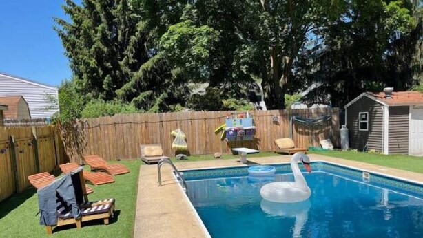 A backyard with a swimming pool, a wooden fence, and a small shed. - Inground Pool w/ Fully fenced Yard/ Arcade/  6 beds incl Tri-Bunk/ Theatre  (Wyoming)