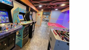 A room with a foosball table, a ping pong table, and a gaming area with multiple arcade machines. - Inground Pool w/ Fully fenced Yard/ Arcade/  6 beds incl Tri-Bunk/ Theatre  (Wyoming)