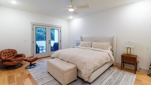 Une chambre à coucher avec un lit, une chaise, une petite table et une fenêtre.