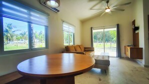 A spacious room with a large round table, a sofa, and a ceiling fan. - Cloud 9 - new ocean view house in La Boca with WiFi, AC (La Boca)