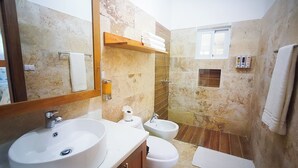 A bathroom with a sink, toilet, bidet, and a mirror. There is a towel rack with towels, a shelf with toiletries, and a window. - Cloud 9 - new ocean view house in La Boca with WiFi, AC (La Boca)