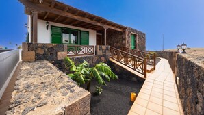 A coastal building with a stone facade, green shutters, and a wooden balcony. - Casa Morro Blanco - Four Bedroom Villa, Sleeps 8 (Conil)
