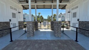 A covered parking area with stone pillars, metal railings, and a gated entrance. - Winter monthly rates 3000 fully furnished  (Panama City Beach)