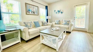 A modern living room with two white sofas, a coffee table, and a side table. - Winter monthly rates 3000 fully furnished  (Panama City Beach)