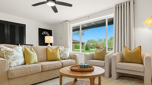 A living room with a beige sofa, a round wooden coffee table, and a striped armchair. - New! Modern 2BR by Downtown Royal Oak | King Beds (Royal Oak)