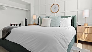 A neatly arranged bedroom with a large bed, bedside tables, and a wall-mounted artwork. - New! Modern 2BR by Downtown Royal Oak | King Beds (Royal Oak)