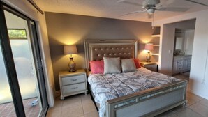 A bedroom with a bed, two bedside tables, a ceiling fan, and a bathroom visible through an open door. - Literally 3 mins from Siesta with its number 1 beaches!!!!
Location! Location! (Sarasota)