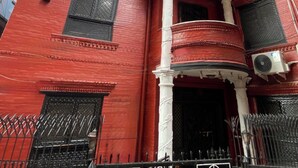 A red building with white columns and balconies.