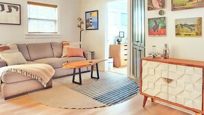 A living room with a sofa, coffee table, and a cabinet. - Stylish Douglas Retreat - Steps from Dunes Resort! (Douglas)
